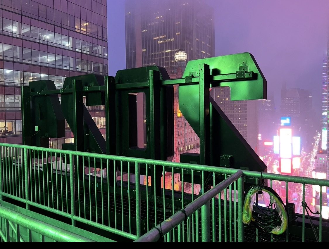 Rooftop signage overlooking a foggy Times Square at night